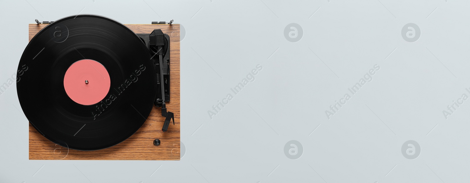 Photo of Modern turntable with vinyl record on light background, top view