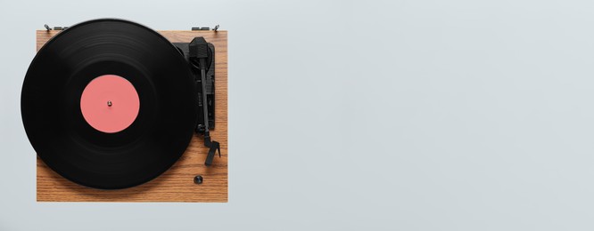 Photo of Modern turntable with vinyl record on light background, top view