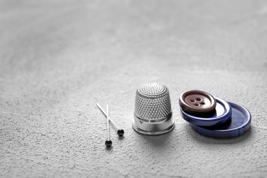 Photo of Set of tailoring accessories on grey background, closeup