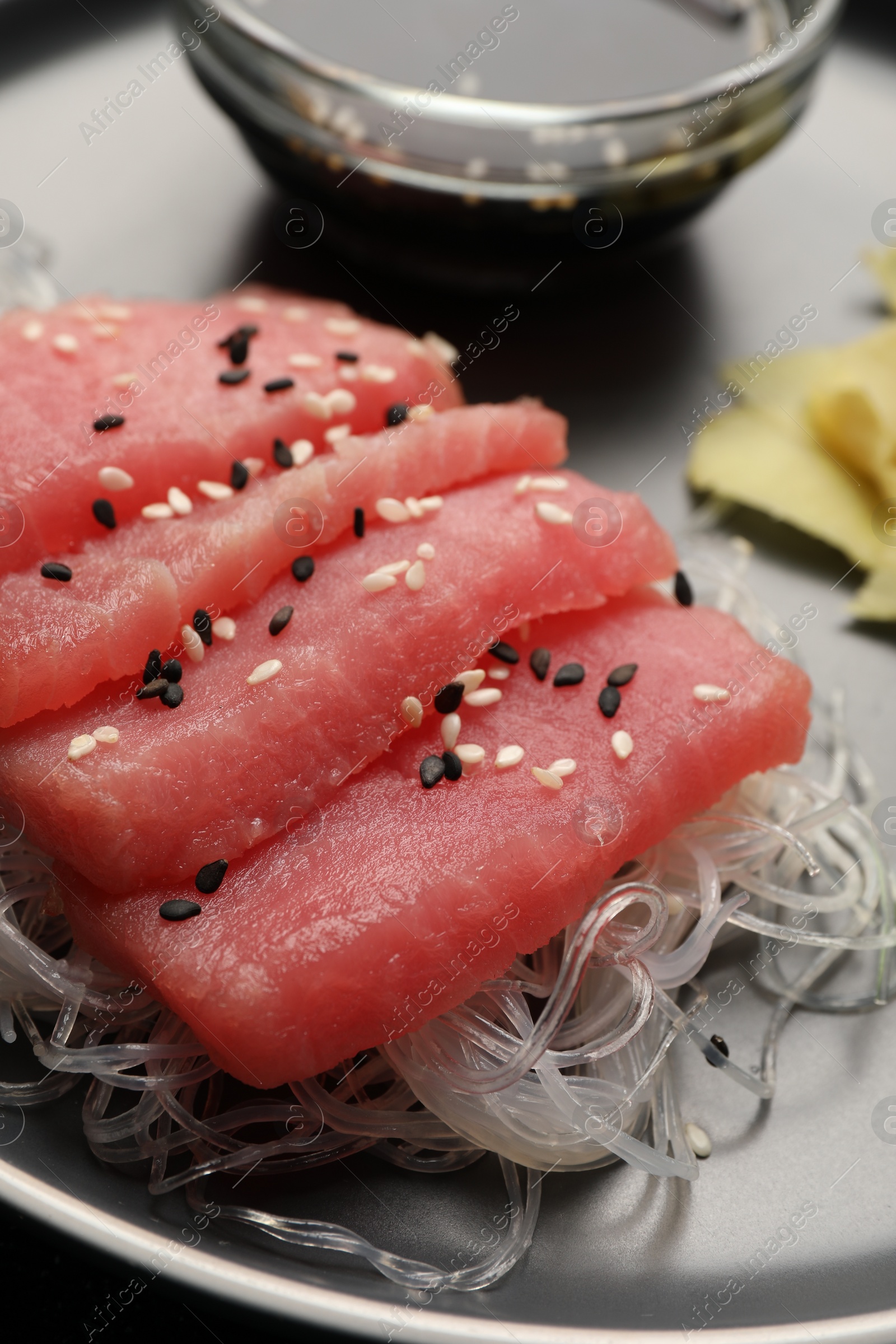 Photo of Tasty sashimi (pieces of fresh raw tuna) and glass noodles on plate, closeup