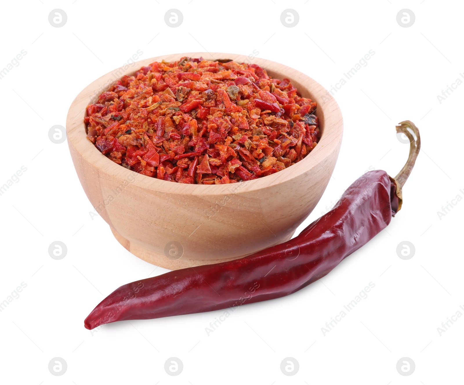 Photo of Aromatic spice. Red chili pepper flakes in bowl and pod isolated on white