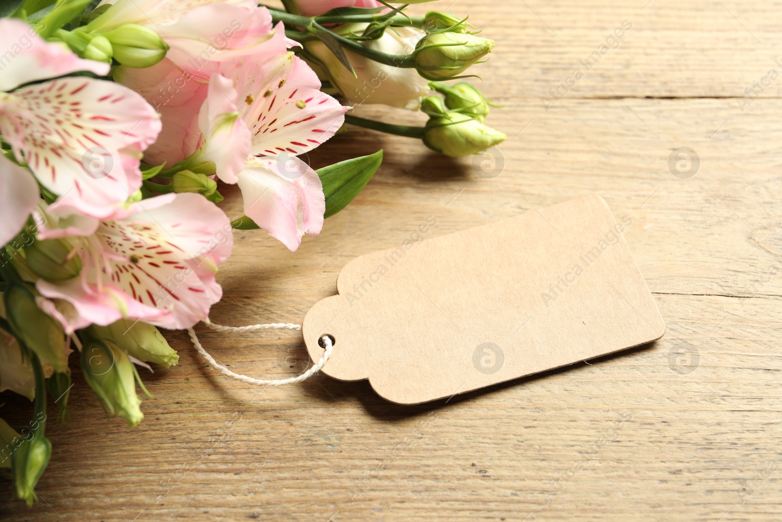 Photo of Happy Mother's Day. Beautiful flowers with blank card on wooden table, closeup