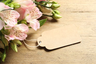 Happy Mother's Day. Beautiful flowers with blank card on wooden table, closeup