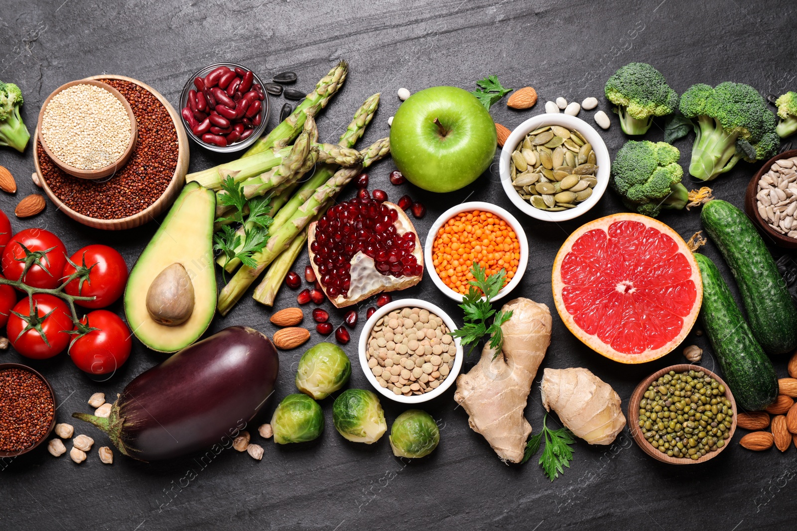 Photo of Fresh vegetables, fruits and seeds on black table, flat lay