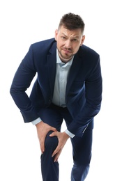 Portrait of businessman having knee problems on white background