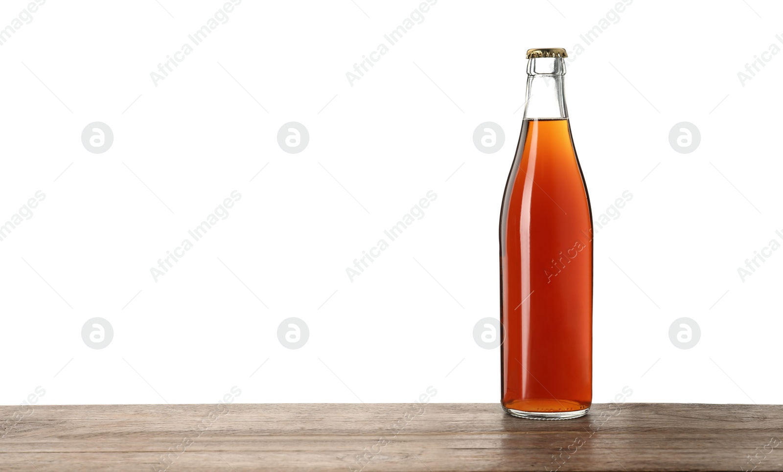 Photo of Bottle of delicious kvass on wooden table against white background