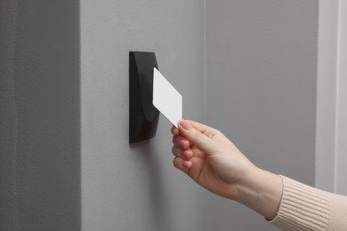 Photo of Woman opening magnetic door lock with key card, closeup. Home security