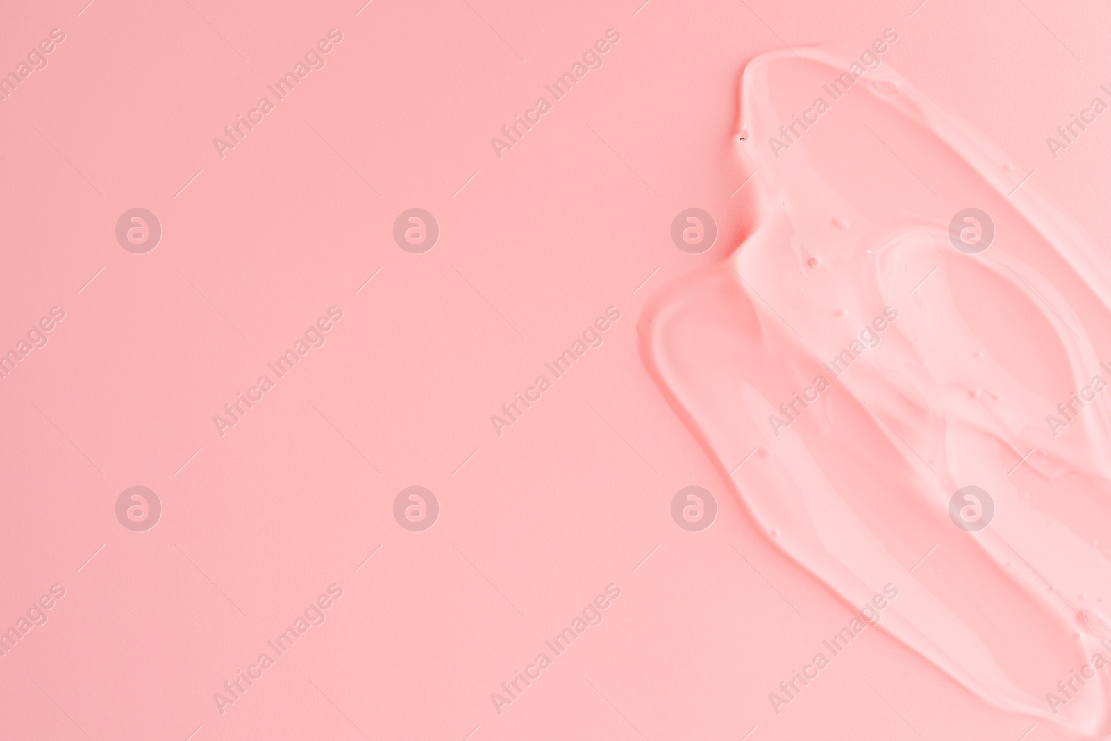 Photo of Sample of transparent gel on pink background, top view. Space for text