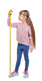 Photo of Little girl measuring her height on white background
