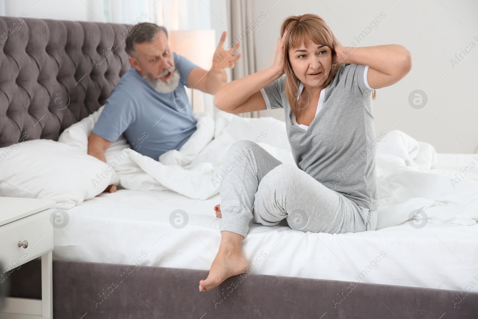 Photo of Mature couple with problem in relationship on bed at home