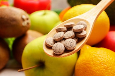 Photo of Dietary supplements. Spoon with pills over food products, closeup