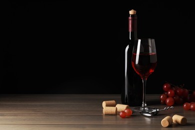 Photo of Wine, corks, grapes and corkscrew on wooden table. Space for text