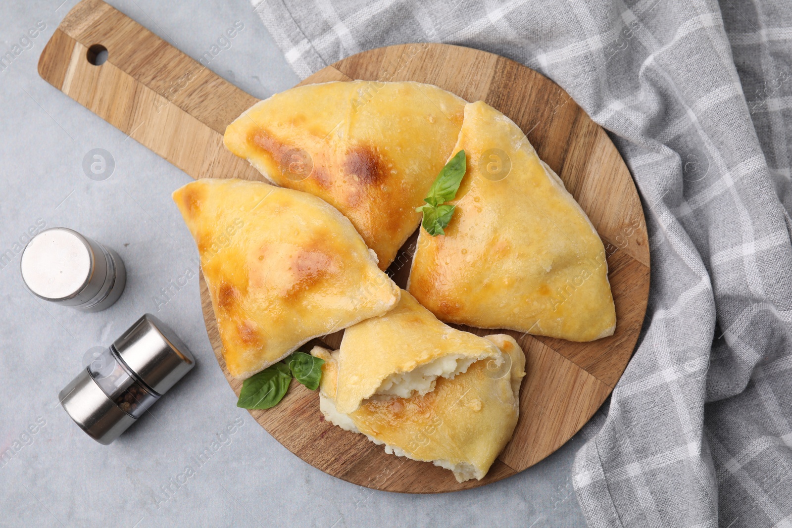 Photo of Delicious samosas and basil served on grey table, flat lay
