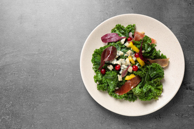 Photo of Tasty fresh kale salad on grey table, top view. Space for text