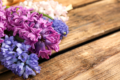 Beautiful spring hyacinth flowers on wooden table, closeup. Space for text