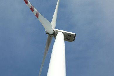 Photo of Modern wind turbine against blue sky, low angle view. Alternative energy source