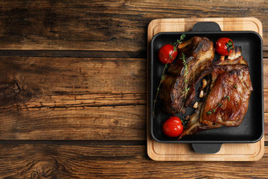 Photo of Delicious roasted ribs served on wooden table, top view. Space for text