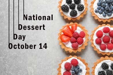 National Dessert Day, October 14. Tasty tartlets with different fresh berries on light grey table, flat lay