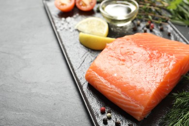 Photo of Fresh raw salmon and ingredients for marinade on black table, closeup. Space for text