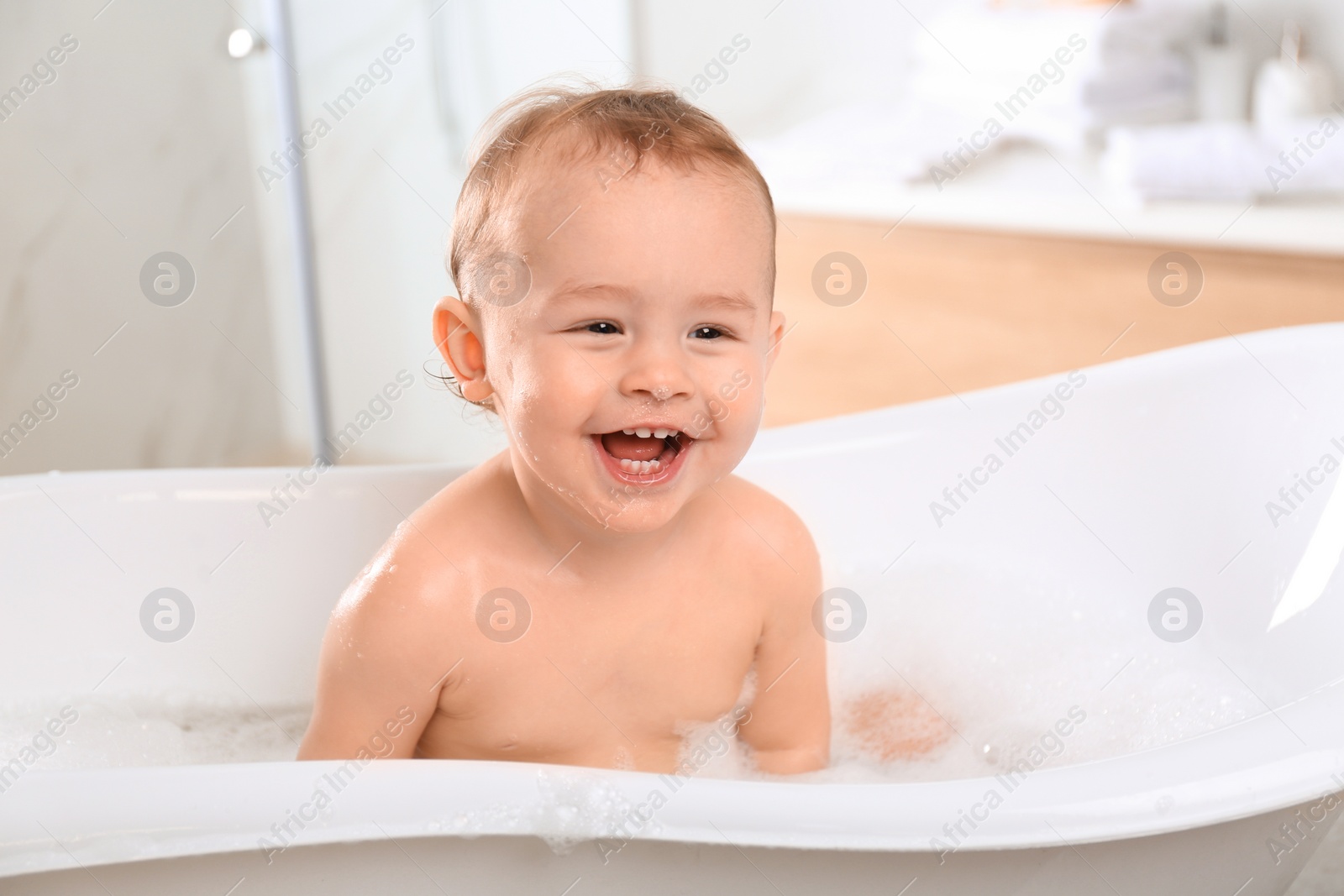 Photo of Cute little baby in bathtub at home