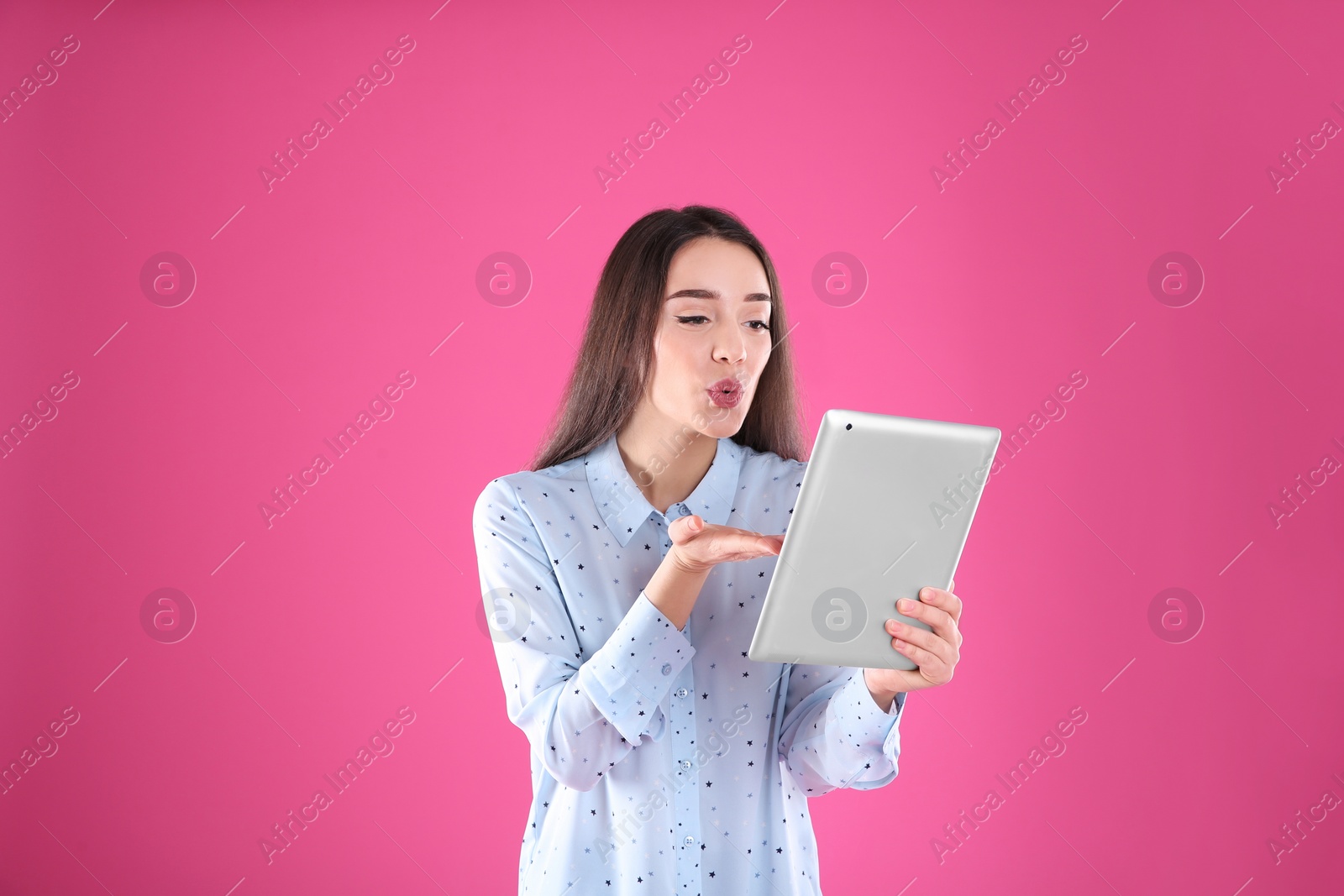 Photo of Woman using tablet for video chat on color background