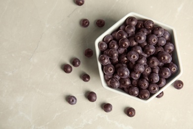 Bowl with fresh acai berries on table, top view