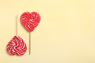 Sweet heart shaped lollipops on beige background, flat lay with space for text. Valentine's day celebration