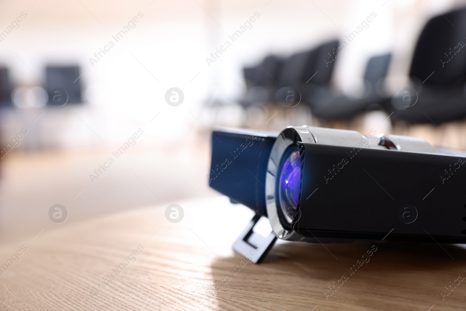 Photo of Modern video projector on table in conference room