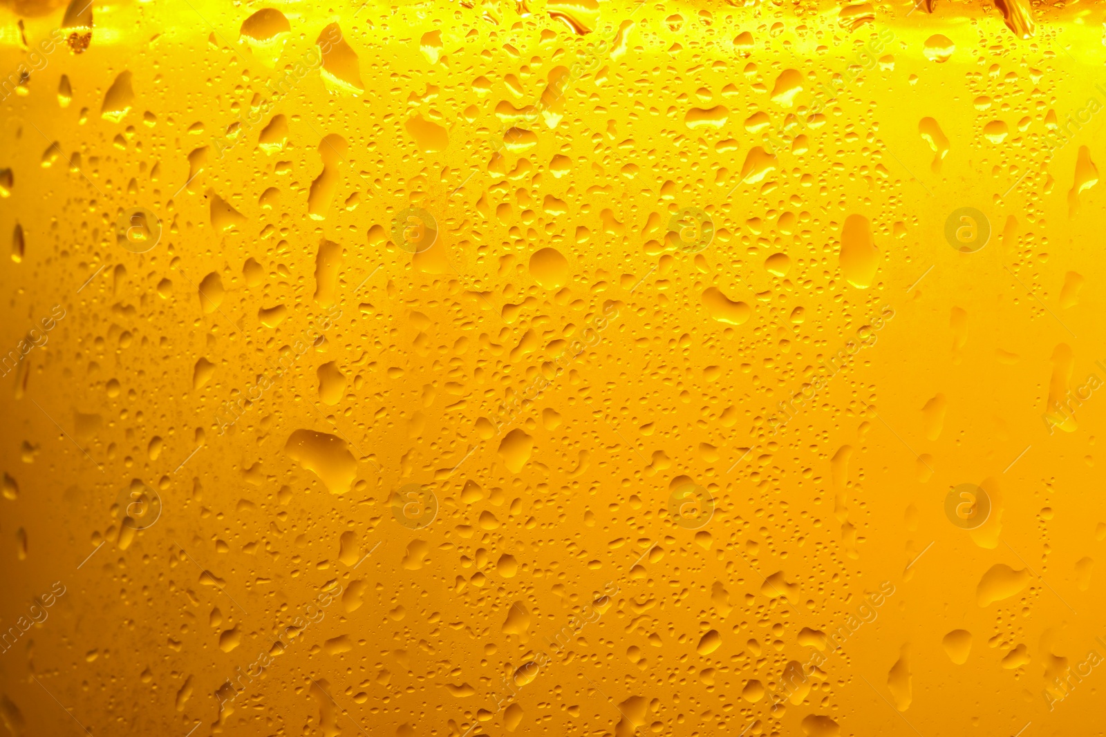 Photo of Glass of tasty cold beer with condensation drops as background, closeup