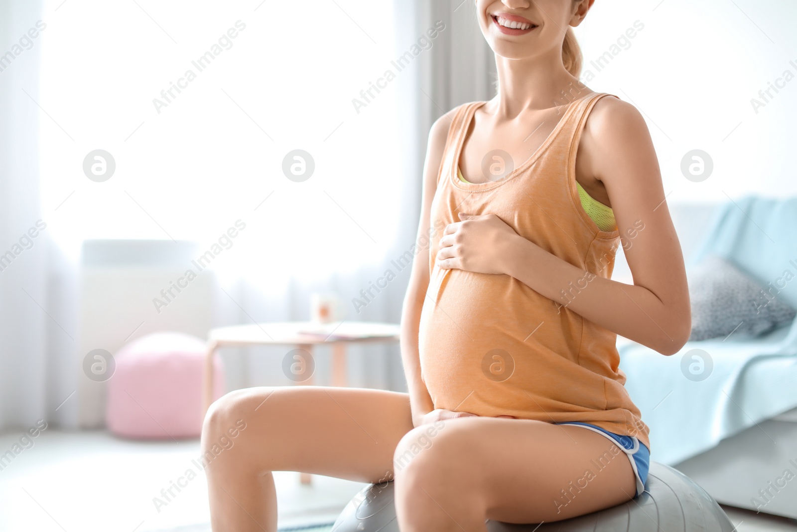 Photo of Young pregnant woman doing exercises at home