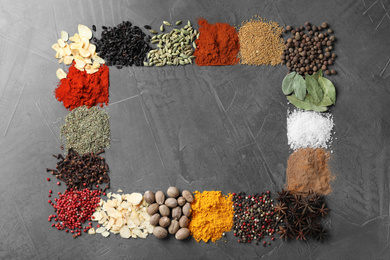 Frame made with different spices on grey background, flat lay. Space for text
