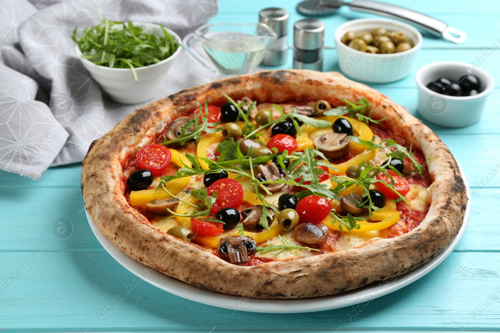Photo of Delicious vegetable pizza on light blue wooden table