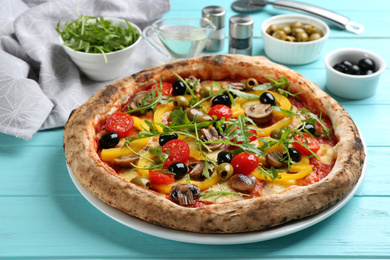 Photo of Delicious vegetable pizza on light blue wooden table