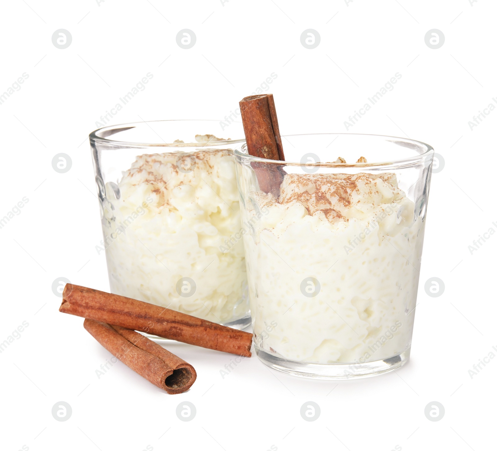 Photo of Creamy rice pudding with cinnamon in glasses on white background