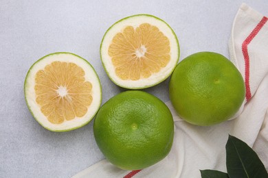 Whole and cut sweetie fruits on light table, flat lay