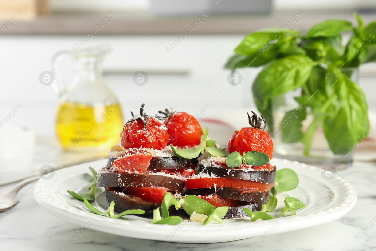 Photo of Baked eggplant with tomatoes, cheese and basil on kitchen table