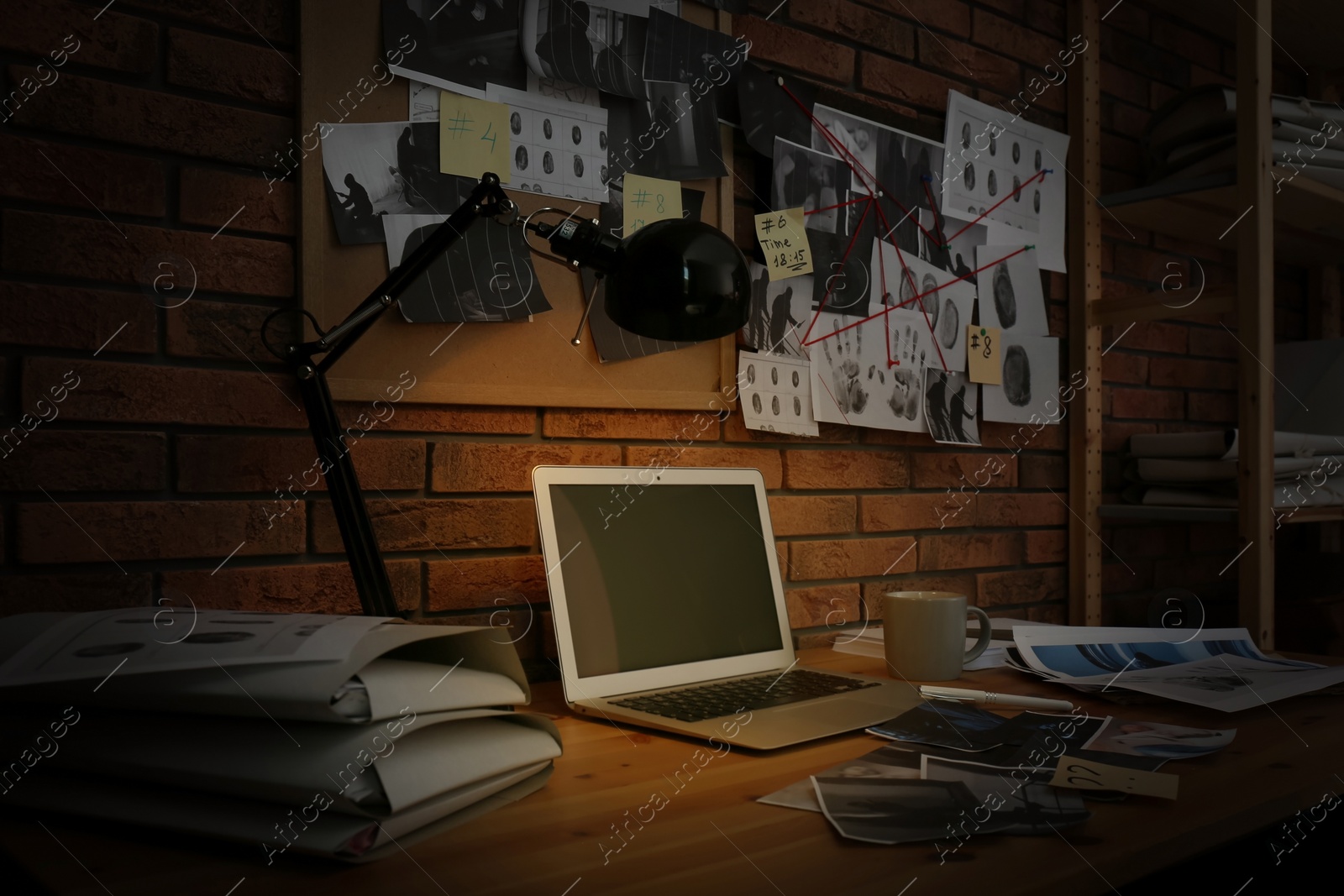 Photo of Workplace with laptop and detective board in office