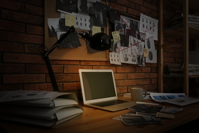 Photo of Workplace with laptop and detective board in office