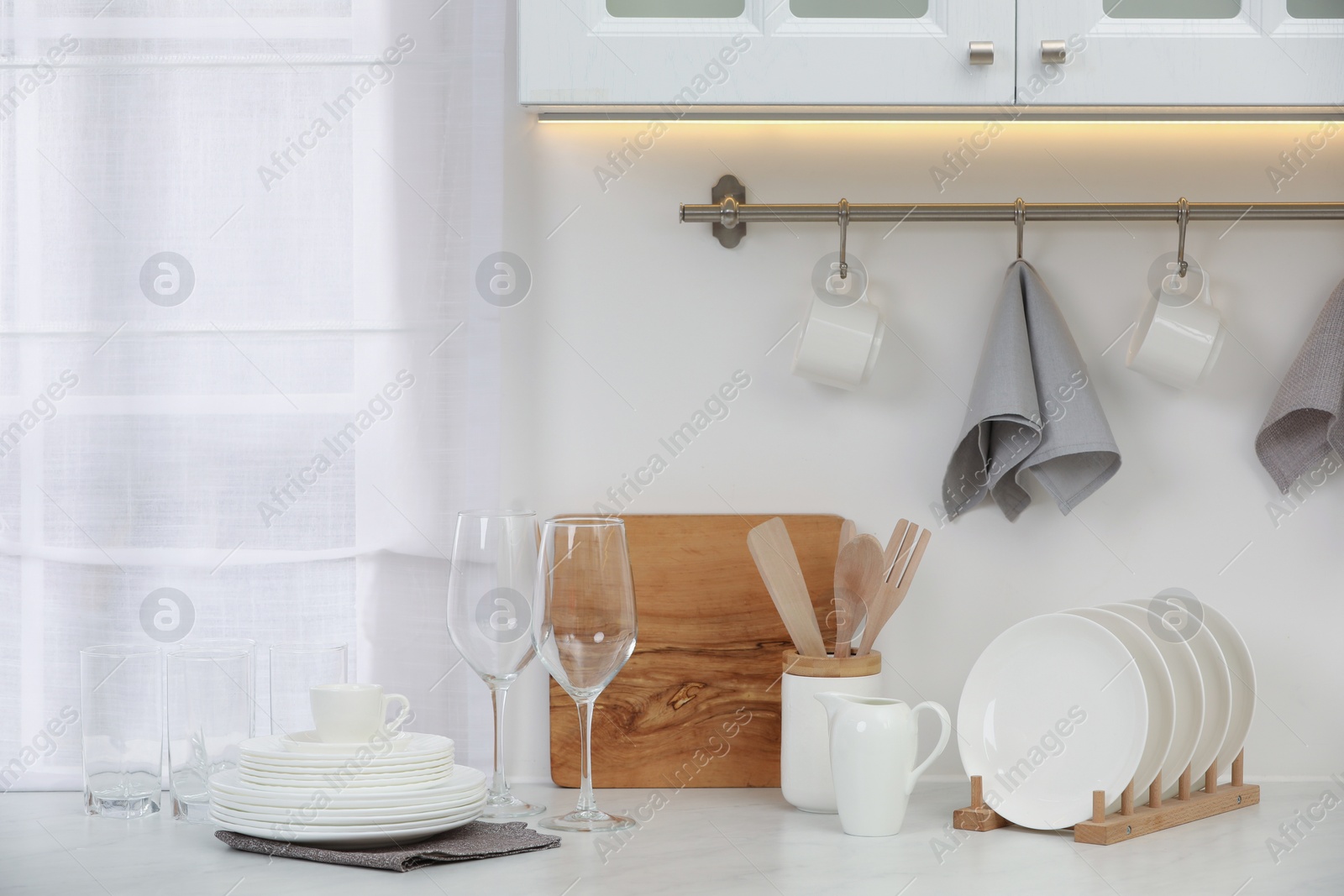 Photo of Clean dishes on light table in kitchen