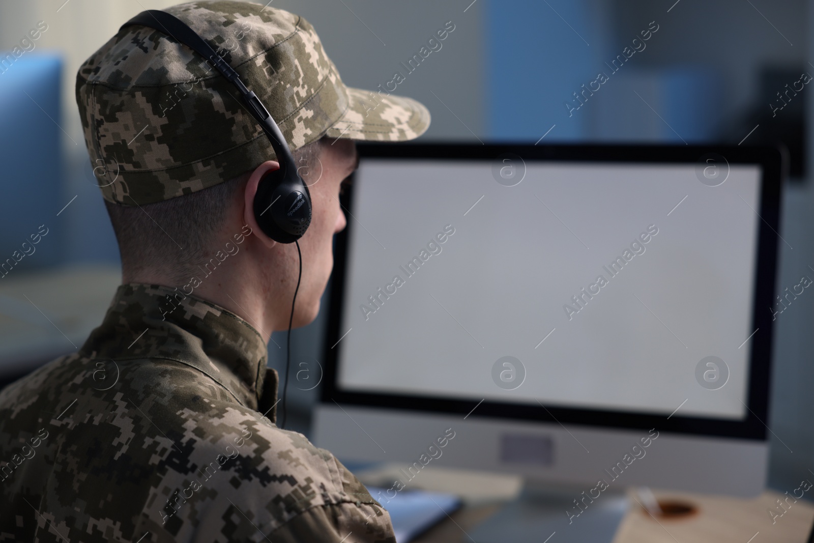 Photo of Military service. Soldier in headphones working in office, space for text