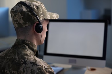 Photo of Military service. Soldier in headphones working in office, space for text