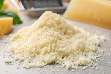 Pile of grated parmesan cheese on light table, closeup