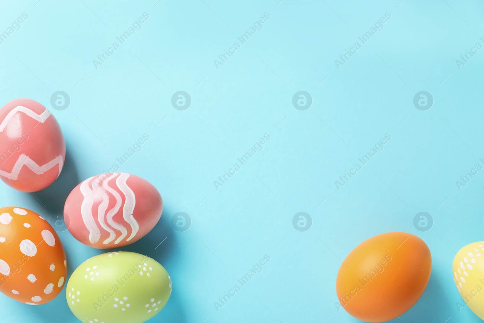 Photo of Flat lay composition of painted Easter eggs on color background, space for text