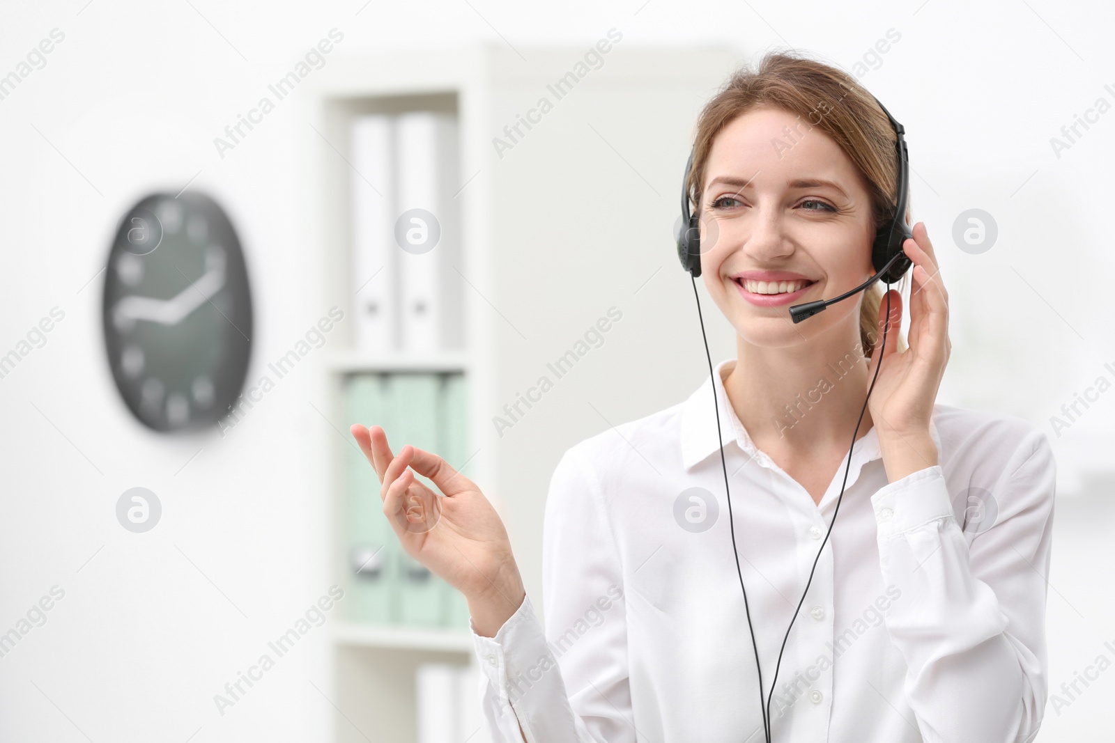 Photo of Young female receptionist with headset in office