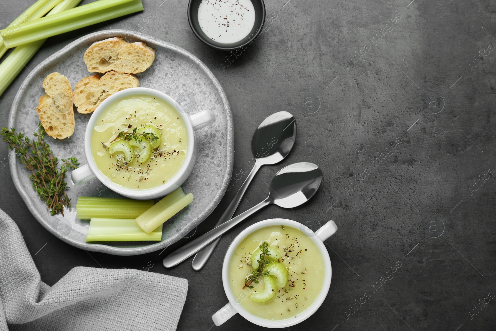 Photo of Delicious celery soup served on gray table, flat lay. Space for text