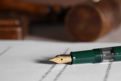 Photo of Fountain pen and paper document on table, closeup with space for text. Notary service