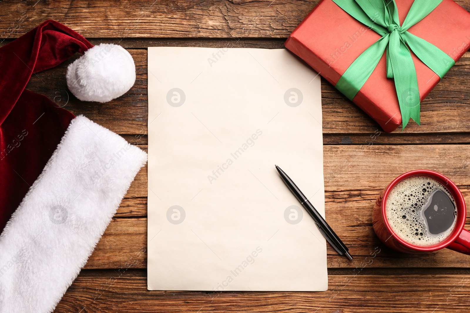 Photo of Flat lay composition with blank sheet of paper on wooden table, space for text. Writing letter to Santa