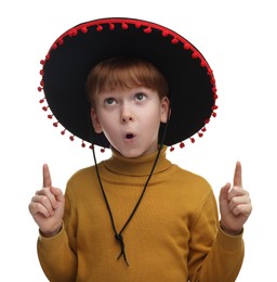 Photo of Surprised boy in Mexican sombrero hat pointing at something on white background