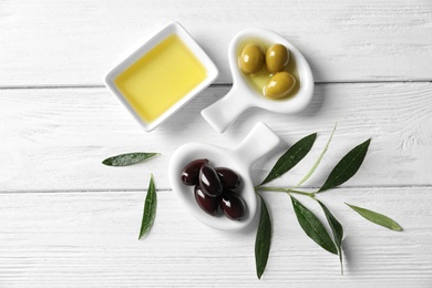 Flat lay composition with fresh olive oil on wooden background