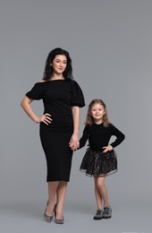 Photo of Beautiful mother with little daughter on grey background